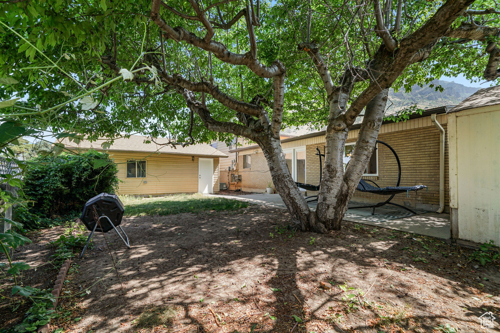 Back of property with brick siding, a patio, and a mountain view