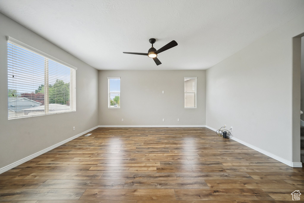Spare room featuring ceiling fan, hardwood / wood-style floors, and baseboards