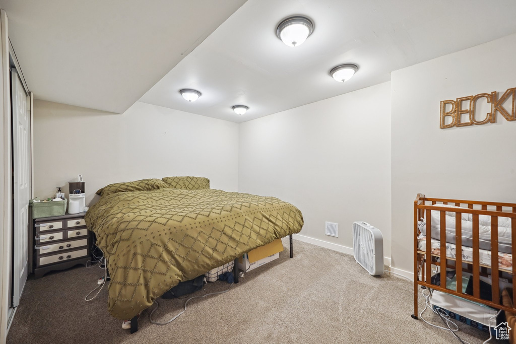 Bedroom featuring carpet and baseboards
