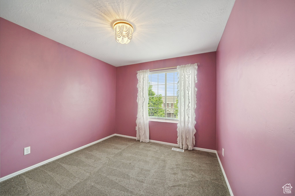 Carpeted empty room featuring baseboards