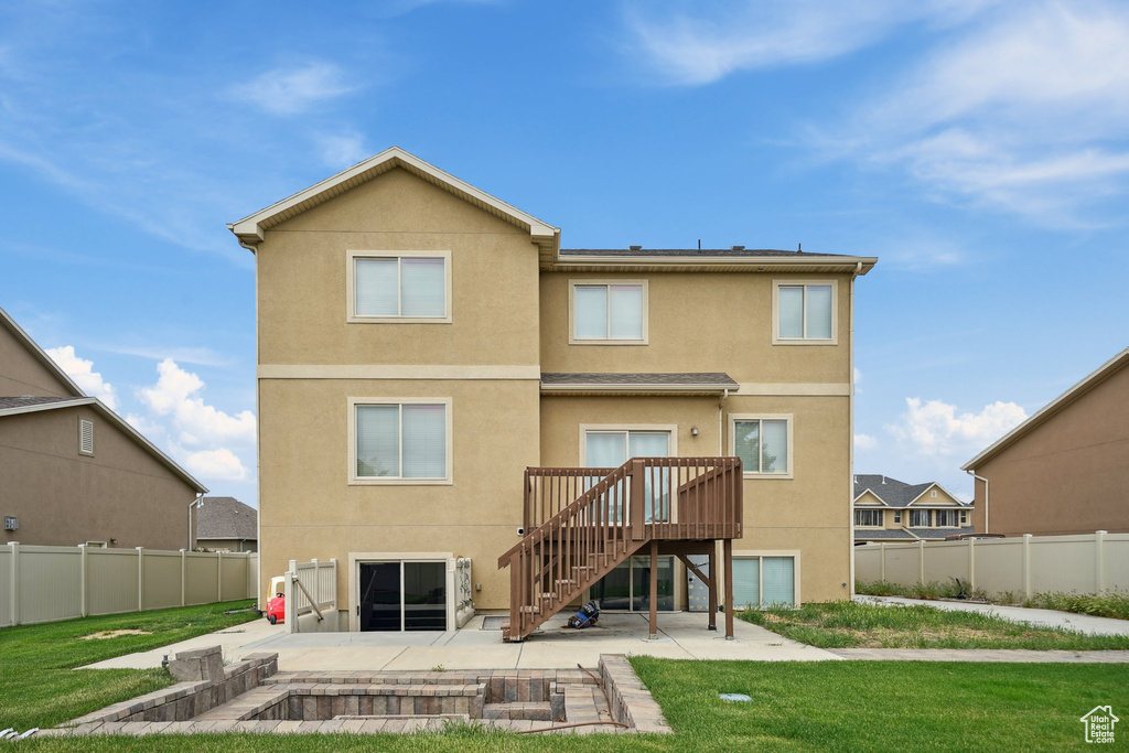 Back of property with a patio area, stucco siding, stairs, and a deck
