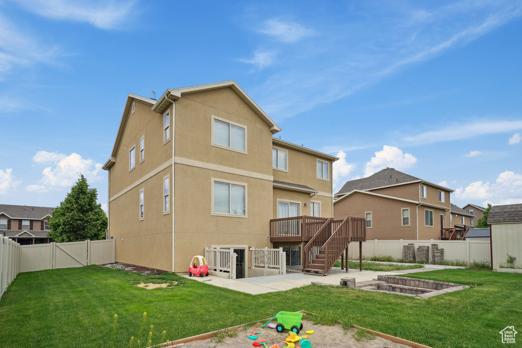 Back of house featuring a patio, stucco siding, stairs, a deck, and a gate