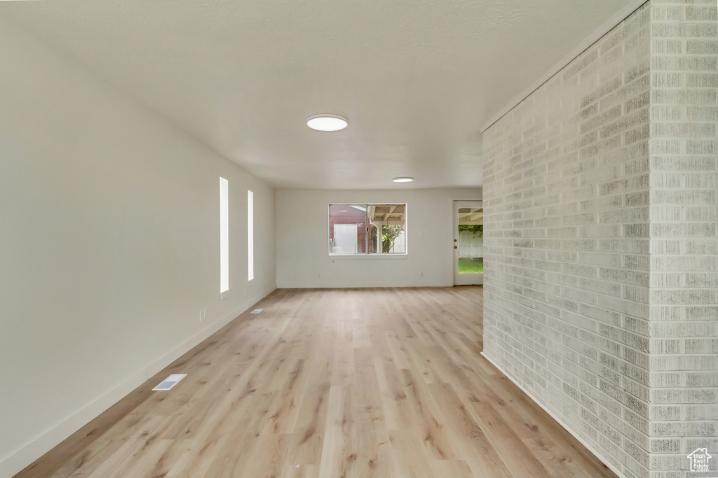 Unfurnished room with light wood finished floors and baseboards