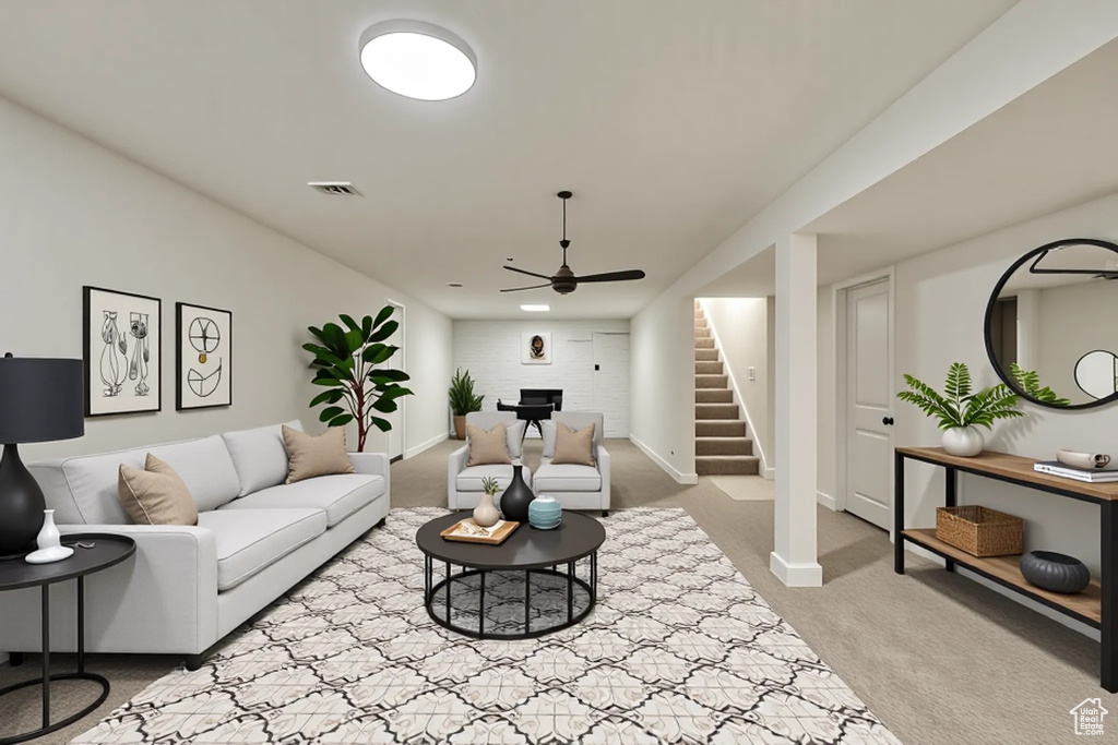 Carpeted living area featuring stairway, ceiling fan, and baseboards
