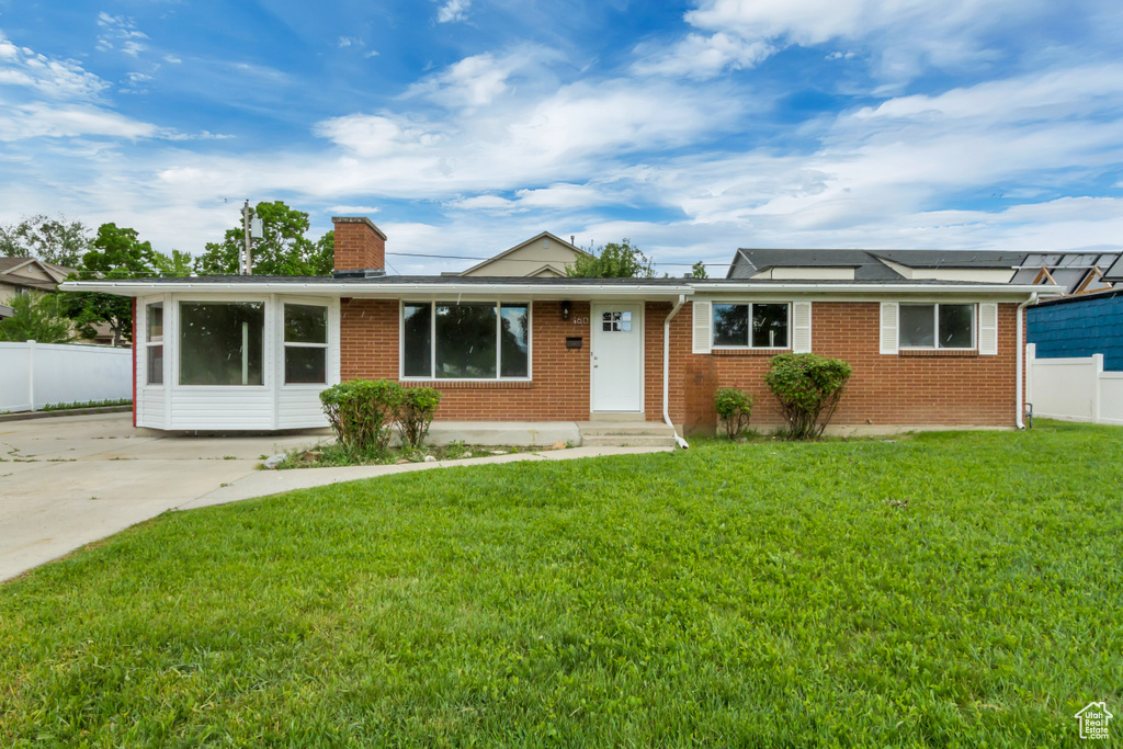 Ranch-style house with brick siding, a chimney, and solar panels