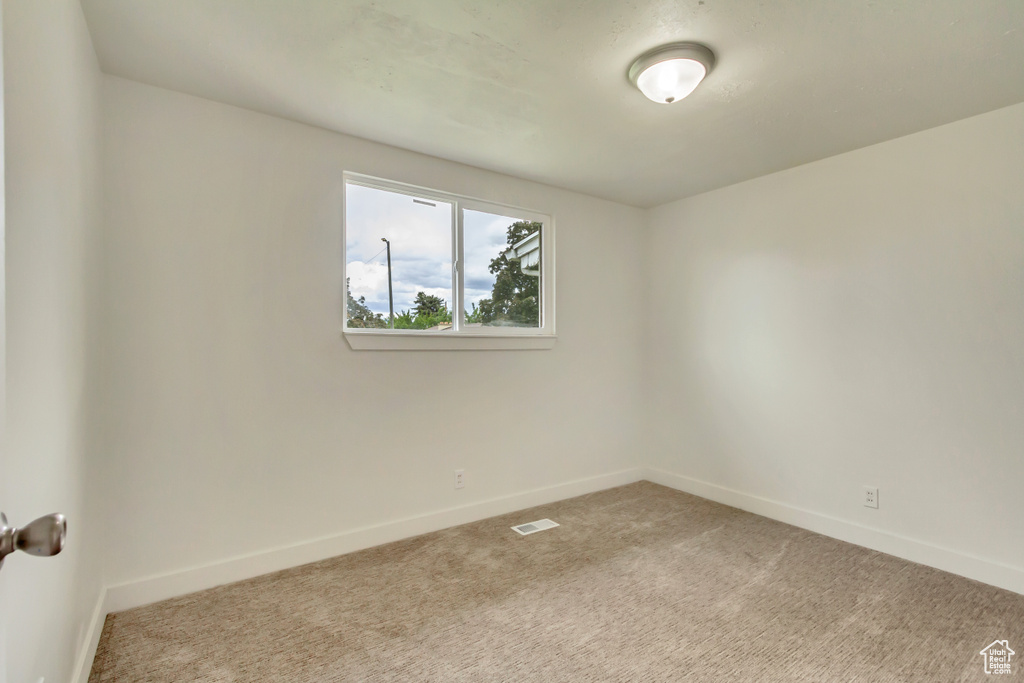 Unfurnished room featuring carpet floors and baseboards
