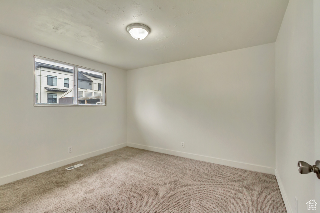 Carpeted empty room featuring baseboards