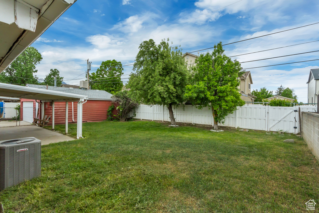 View of yard featuring central AC and a gate