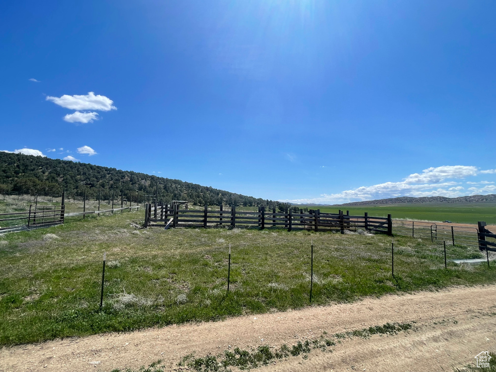 View of yard with a rural view and fence