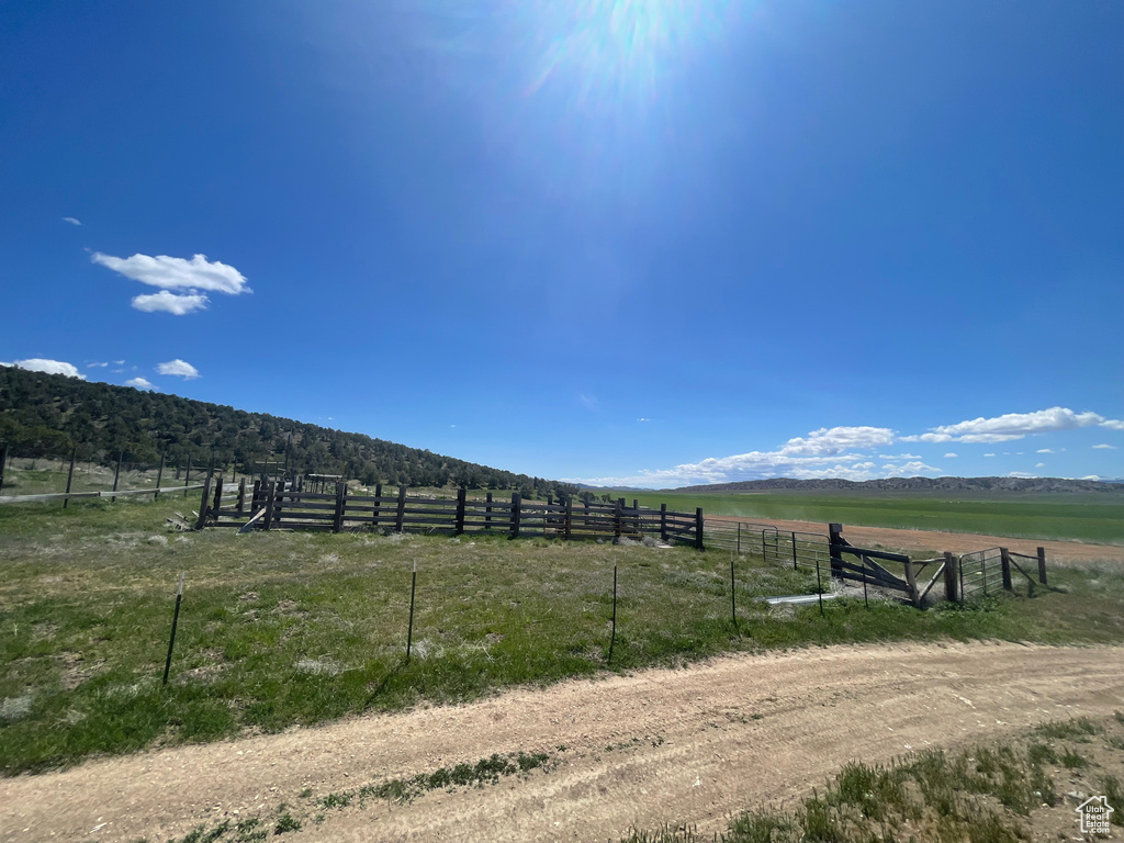 View of yard with a view of rural / pastoral area, fence, and a mountain view