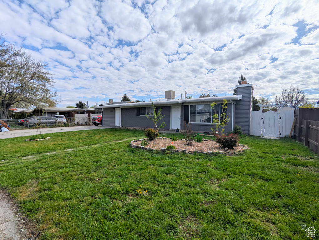 Ranch-style house featuring a chimney, concrete driveway, and a gate