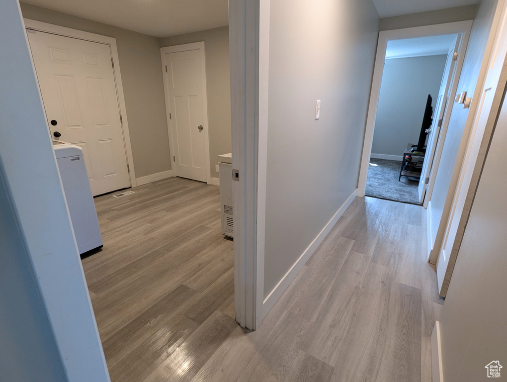 Corridor featuring light wood-style floors and baseboards