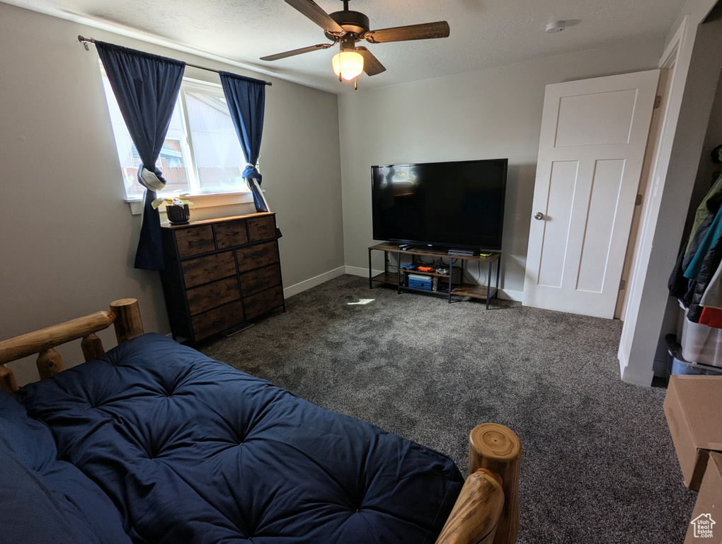 Carpeted bedroom with a ceiling fan and baseboards