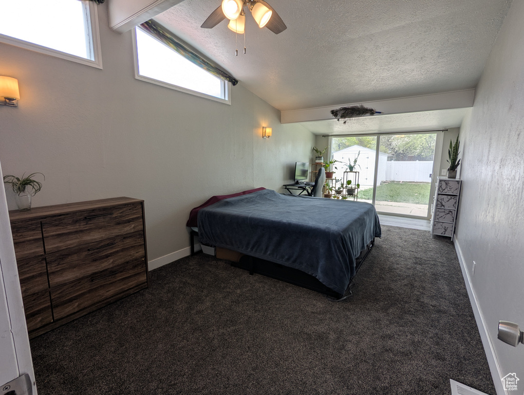 Carpeted bedroom with access to exterior, vaulted ceiling, a textured ceiling, ceiling fan, and baseboards