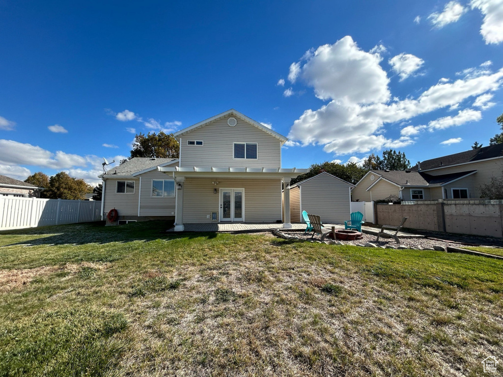 Rear view of property featuring french doors, an outdoor fire pit, and a patio