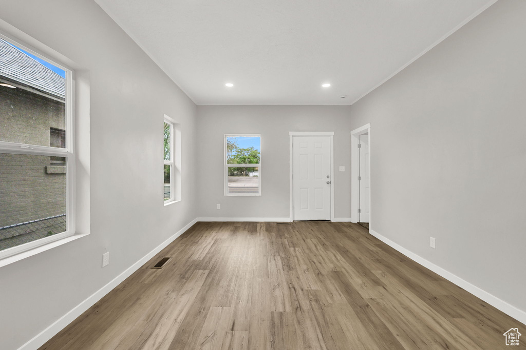 Unfurnished room featuring wood finished floors, baseboards, and recessed lighting