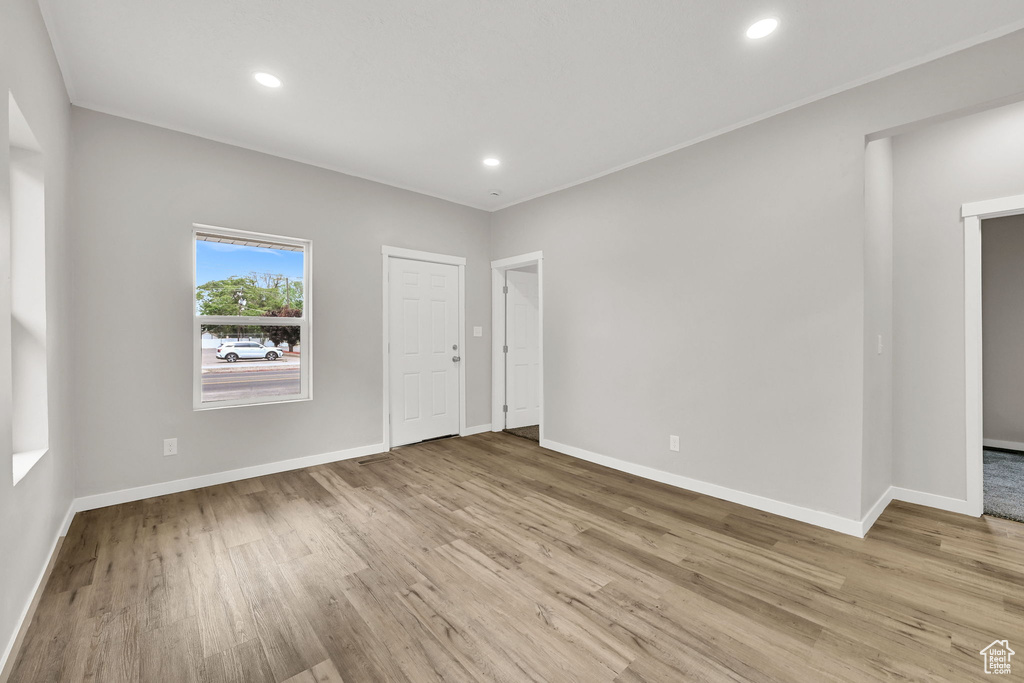 Unfurnished room with wood finished floors, baseboards, and recessed lighting