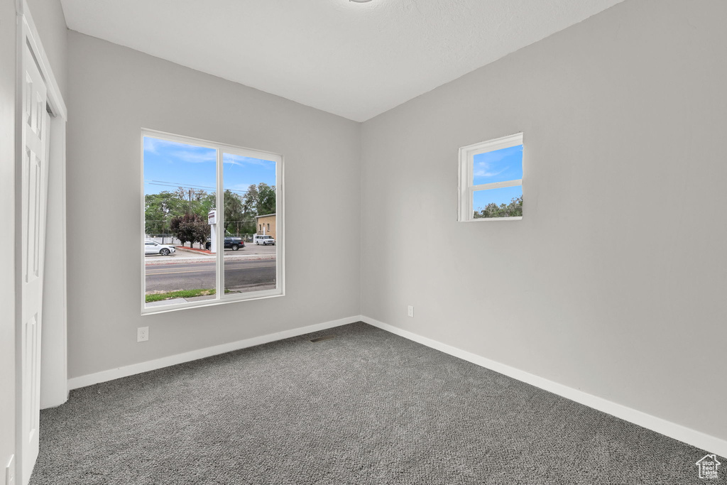 Empty room featuring carpet and baseboards
