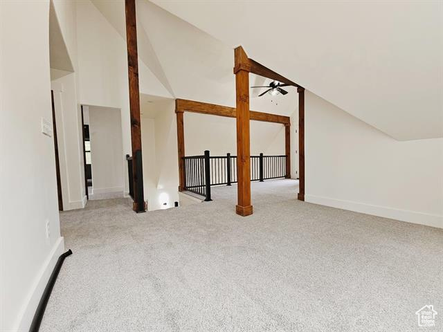 Additional living space with a ceiling fan, carpet flooring, lofted ceiling, and baseboards