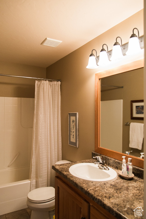 Bathroom featuring toilet, vanity, and shower / tub combo with curtain