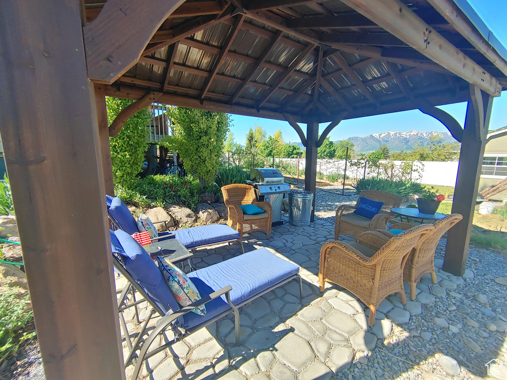 View of patio / terrace with a gazebo, a mountain view, fence, and a grill