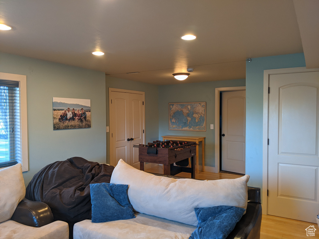 Living room with light wood-style flooring and recessed lighting