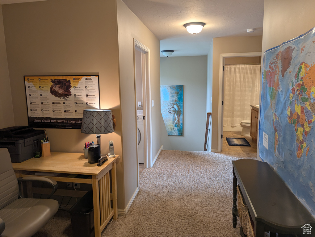 Hallway with light colored carpet and baseboards