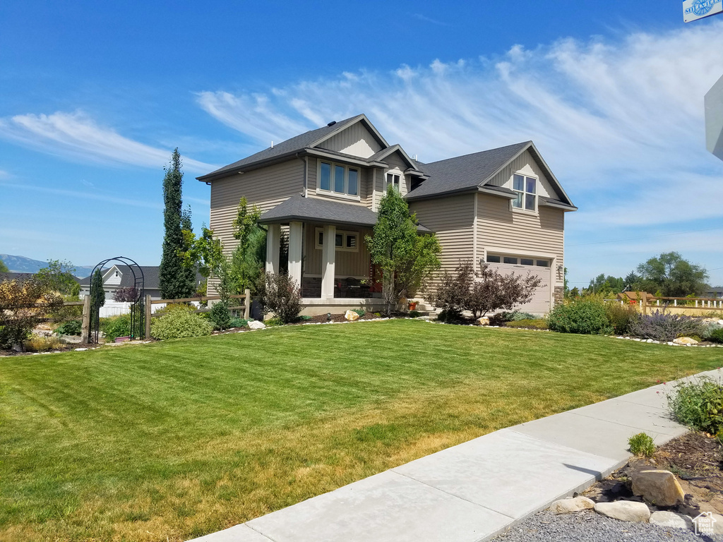 Craftsman-style house featuring an attached garage, a front lawn, and board and batten siding