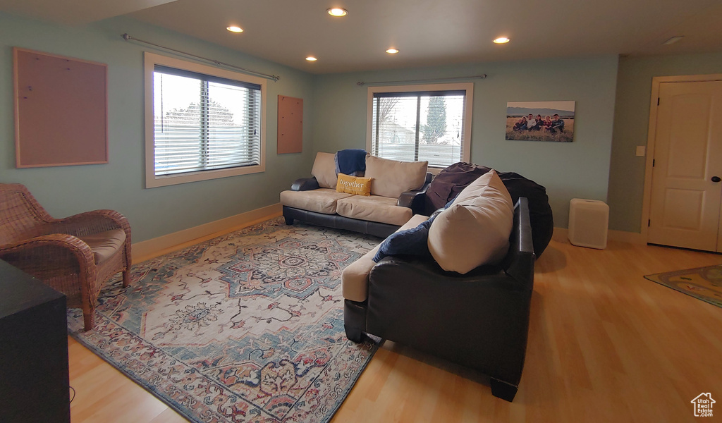 Living room featuring wood finished floors, baseboards, healthy amount of natural light, and recessed lighting