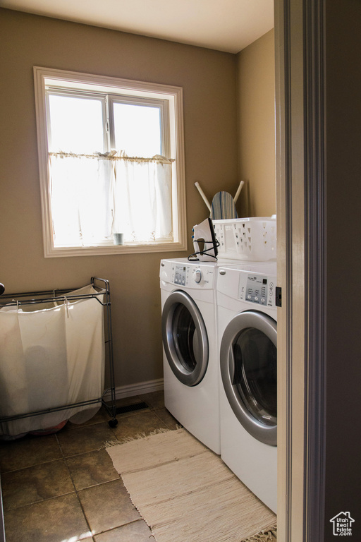Laundry room with washing machine and dryer, baseboards, and tile patterned flooring