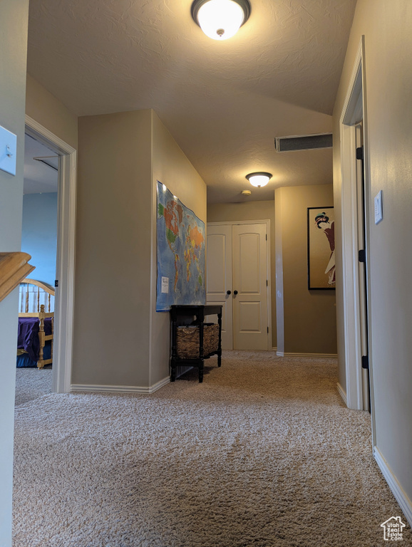 Hallway featuring carpet flooring and baseboards