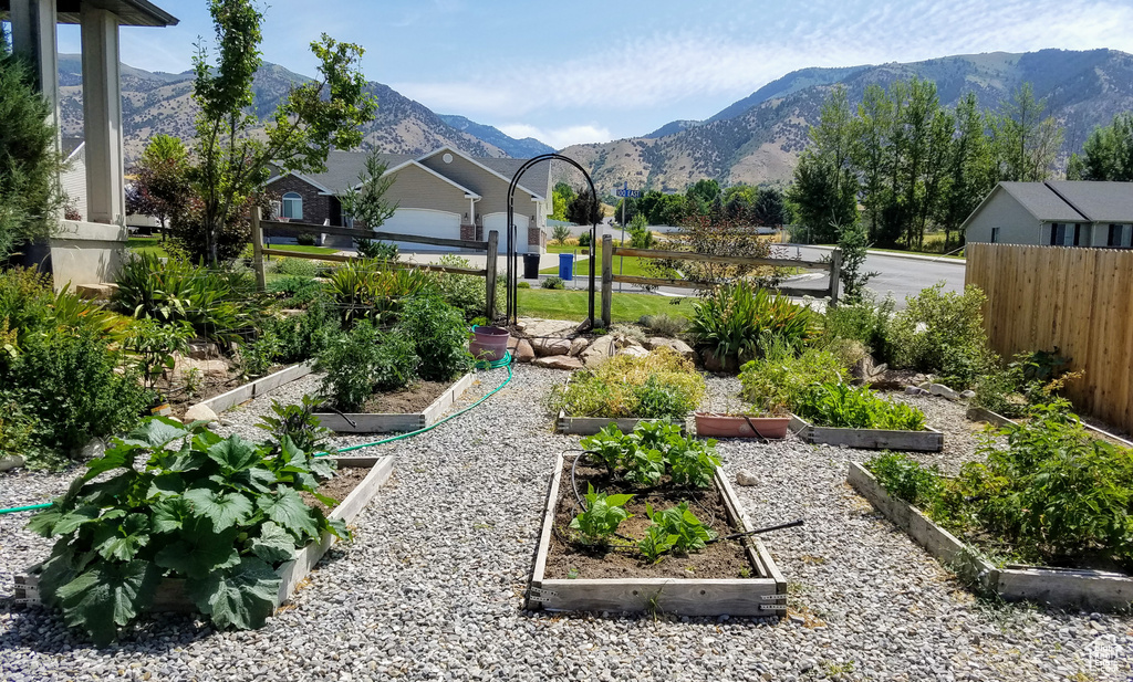 View of yard featuring a garden, a mountain view, and fence
