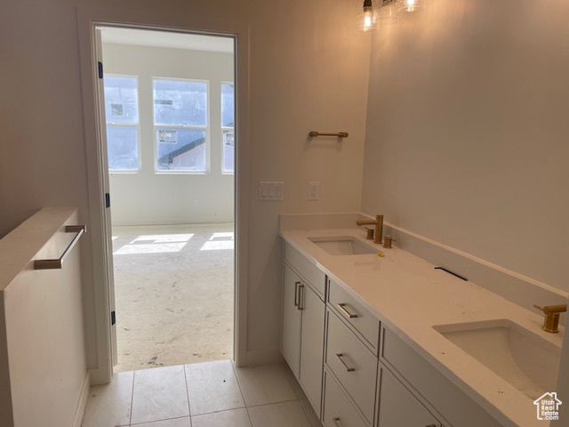 Bathroom with tile patterned flooring, double vanity, and baseboards