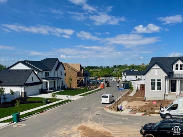 View of asphalt street featuring sidewalks, curbs, and a residential view