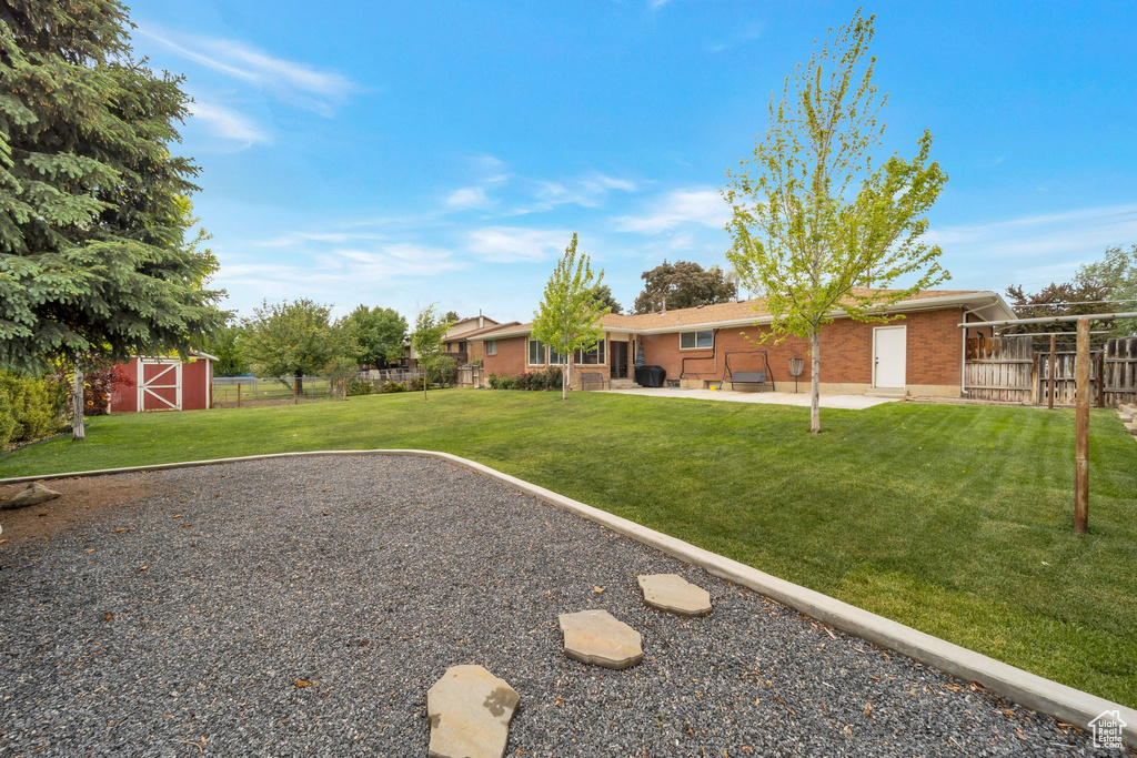 View of yard featuring a patio and an outdoor structure