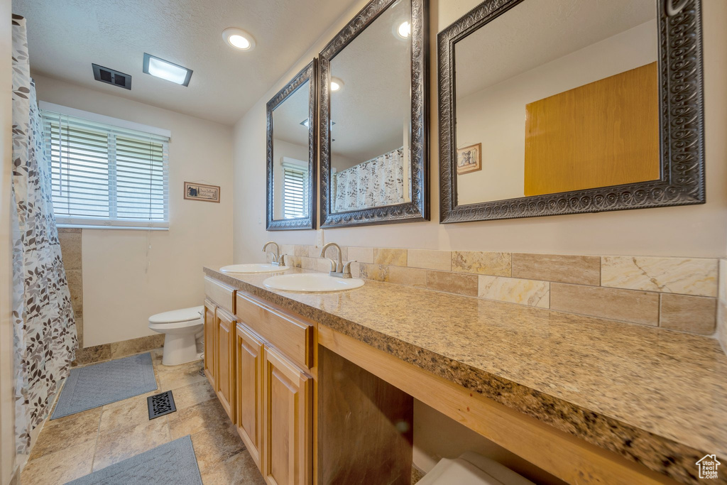 Full bath featuring toilet, vanity, baseboards, recessed lighting, and a shower with shower curtain