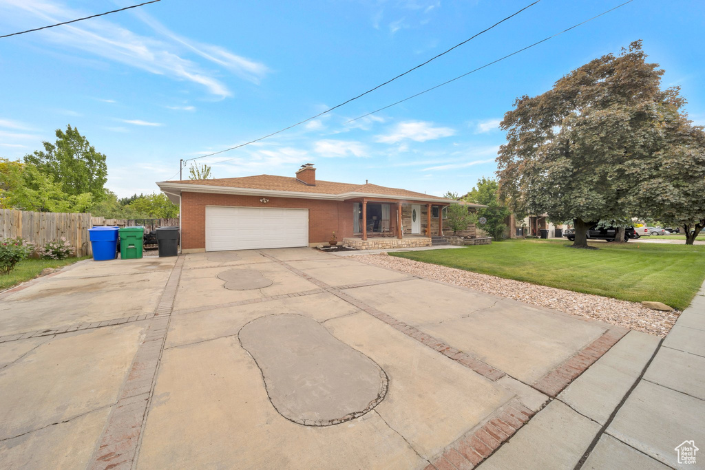 Single story home with a garage, concrete driveway, brick siding, a chimney, and a porch