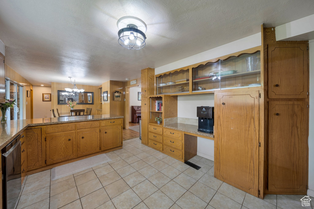 Kitchen featuring a chandelier, light tile patterned flooring, a peninsula, dishwasher, and open shelves
