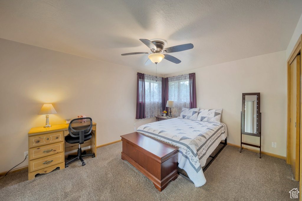 Bedroom with carpet, baseboards, ceiling fan, and a desk