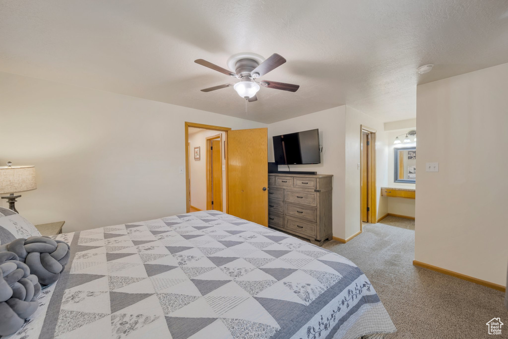 Bedroom with light carpet, baseboards, and a ceiling fan