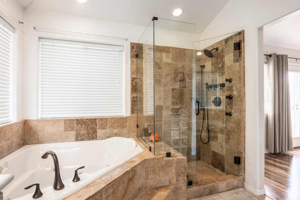 Bathroom featuring a stall shower, a bath, vaulted ceiling, and recessed lighting