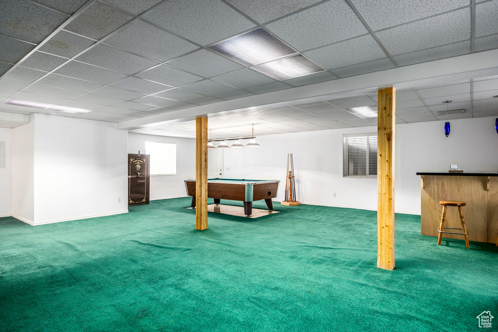 Finished below grade area with billiards, carpet, a bar, a drop ceiling, and baseboards
