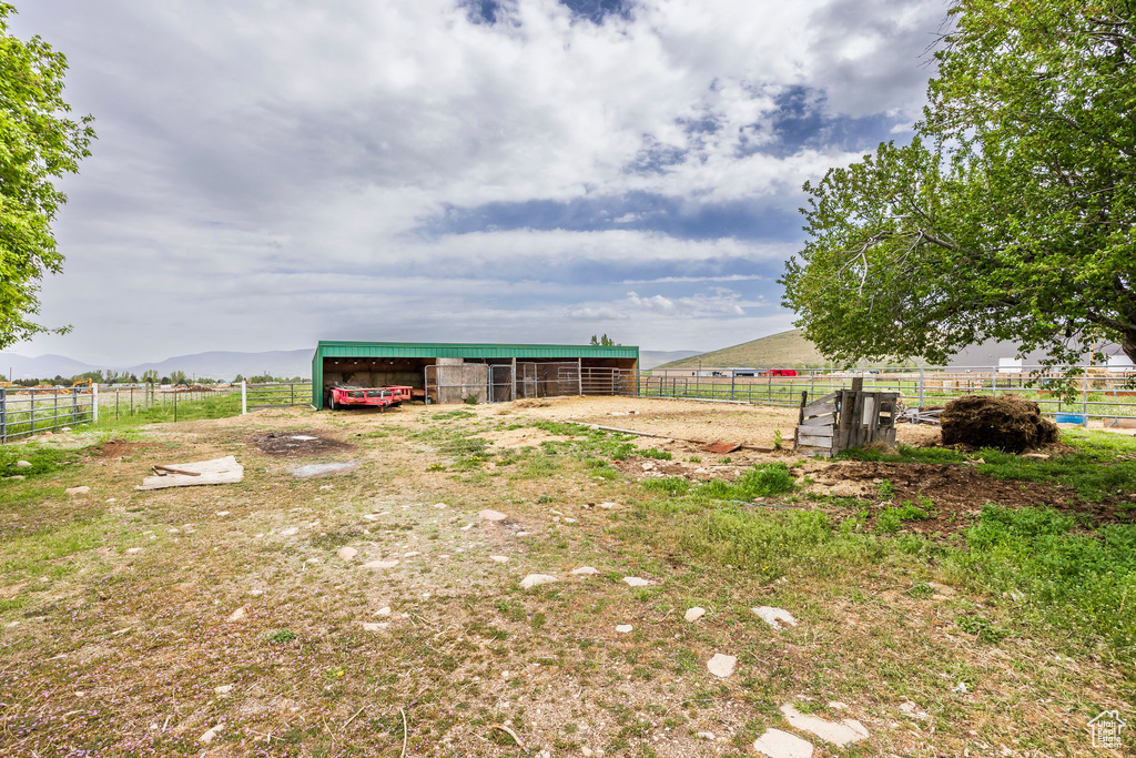 View of yard featuring an outbuilding, an outdoor structure, a detached carport, and a view of rural / pastoral area