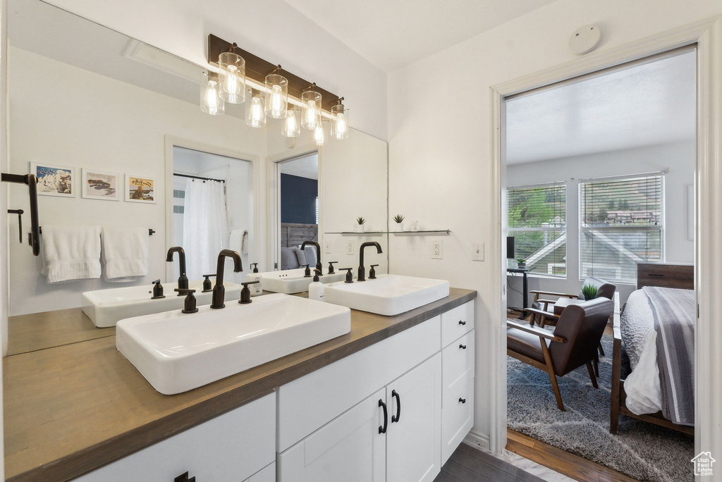 Ensuite bathroom with double vanity and wood finished floors
