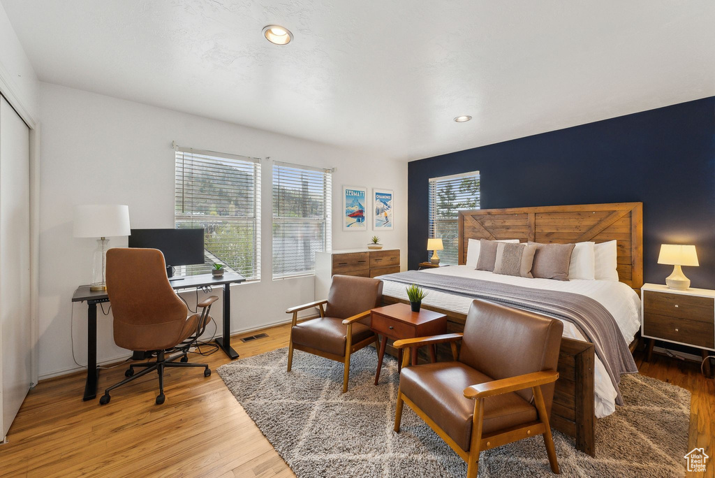 Bedroom with light wood-style flooring, recessed lighting, and a desk