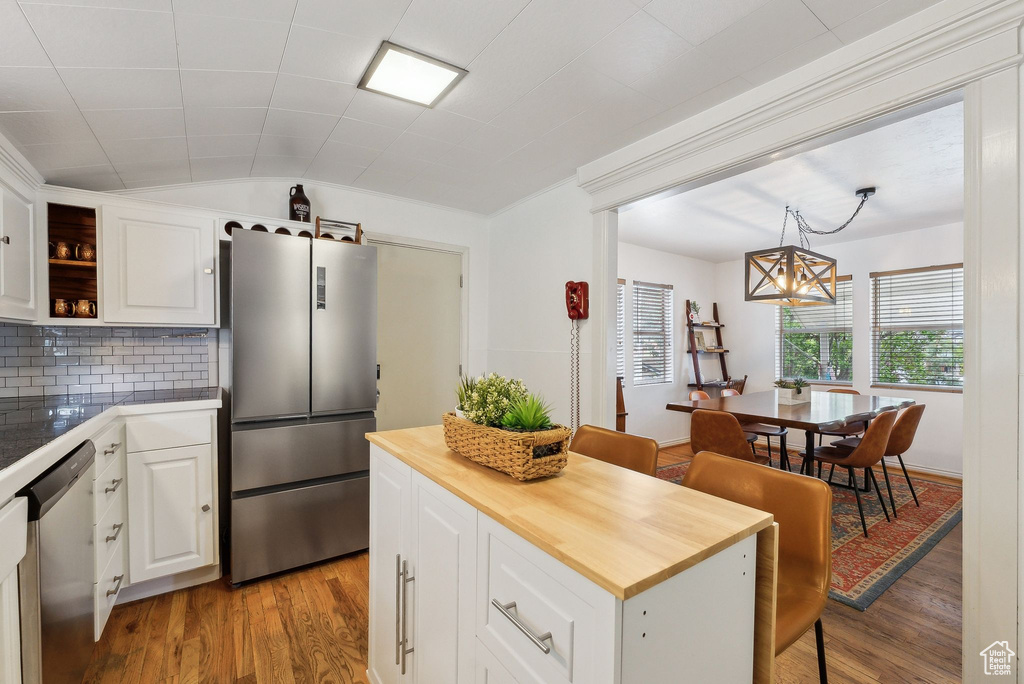 Kitchen featuring stainless steel appliances, butcher block countertops, light wood-style flooring, and white cabinetry