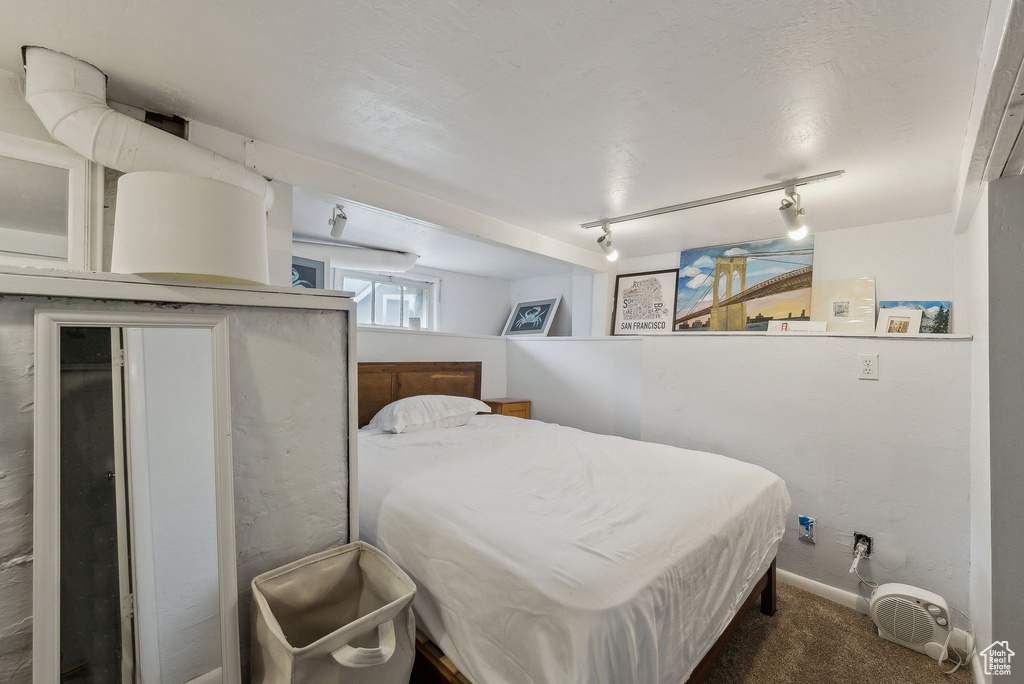 Bedroom featuring carpet, track lighting, and baseboards