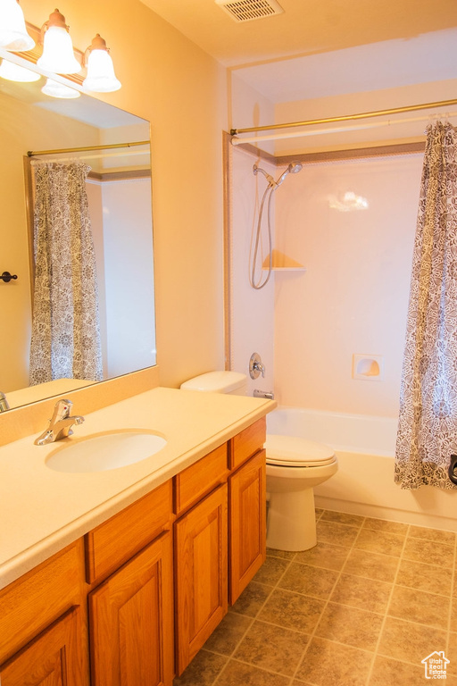 Full bathroom with toilet, shower / bath combination with curtain, and vanity
