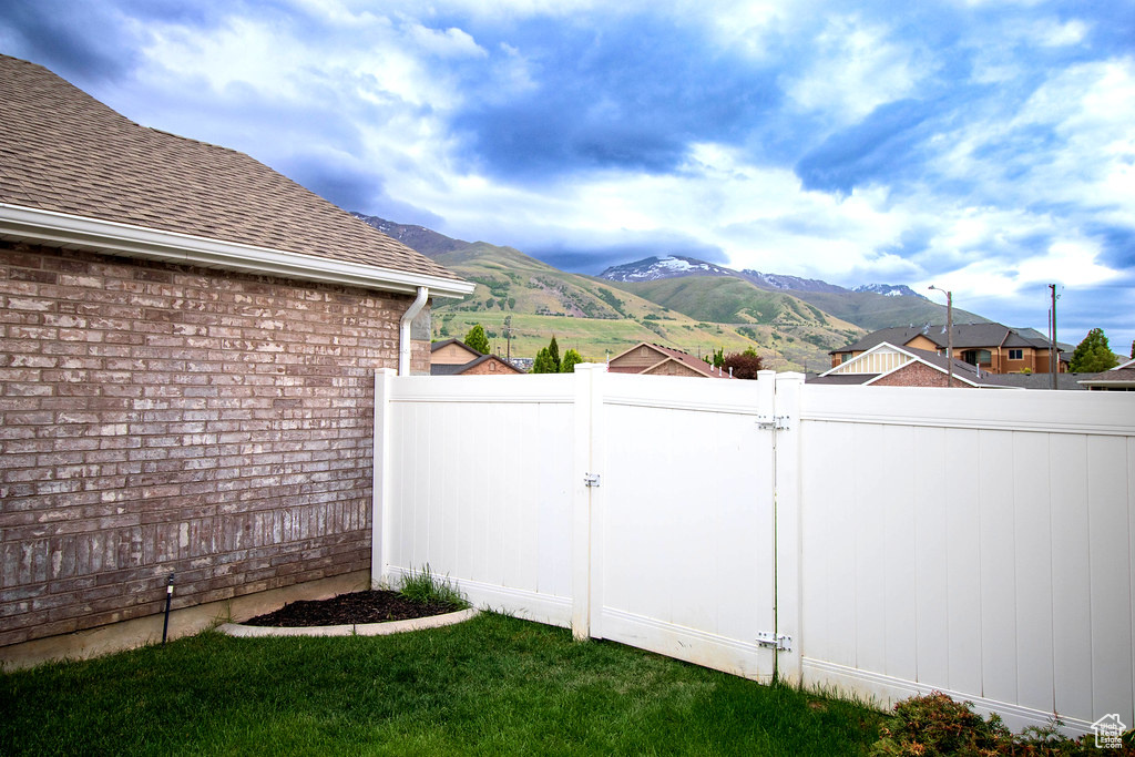 View of yard with a gate, fence, and a mountain view