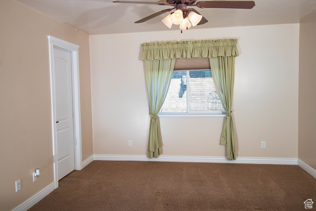 Spare room with carpet floors, ceiling fan, and baseboards